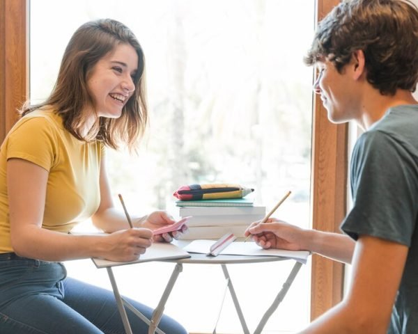 cheerful-teen-couple-studying-near-window_23-2147860619 cheerful-teen-couple-studying-near-window_23-2147860619